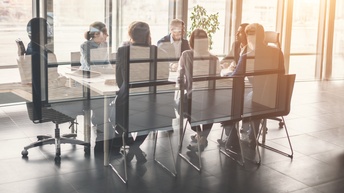 Personen in Besprechungszimmer sitzend