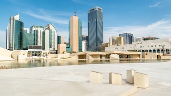 Stadtansicht Abu Dhabi: Panoramablick auf die modernen Wolkenkratzer am Wasser gelegen
