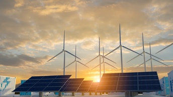 Solarpaneele, Windräder und Container mit der Aufschrift Energy storage im Sonnenuntergang