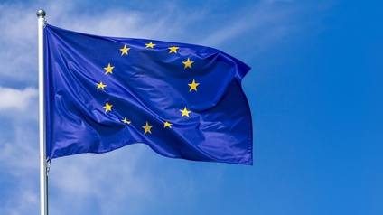Flagge der Europäischen Union im Wind wehend, im Hintergrund blauer Himmel
