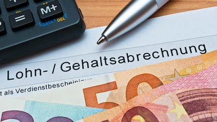 Detailansicht Euroscheine auf Dokumenten liegend, daneben Taschenrechner und Kugelschreiber