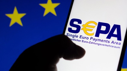 Auf einem Handy-Display steht SEPA - im Hintergrund die Flagge der EU