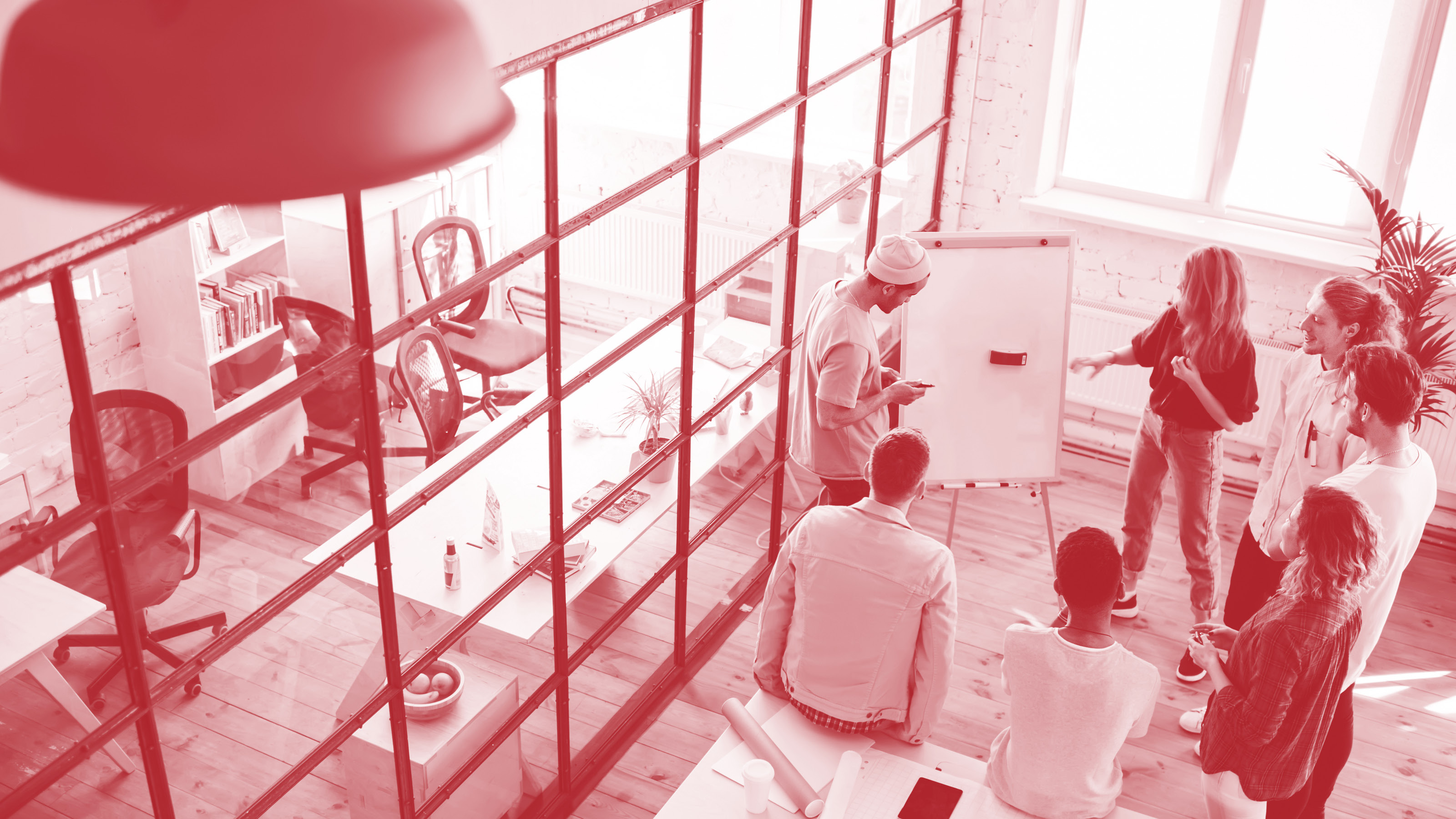 Junges Team beim Brainstorming vor einem Whiteboard in einem offenen Büro
